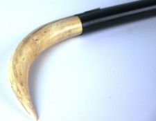 A late nineteenth century ebony and ivory walking stick with ivory foot, tapered ebony stick and