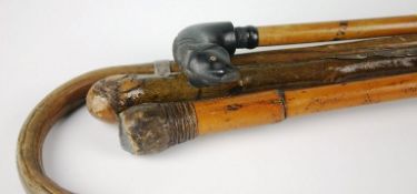 A late 19th Century ebony and malacca walking stick with ebony carved handle in the form of a