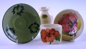 A group of four Moorcroft decorative items including posy vase, saucer and others of various designs