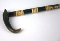 A late nineteenth century horn and ivory walking stick with tapering stick inlaid with bands of
