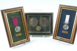 A group of commemorative medals and coins (framed) of various dates and sizes.