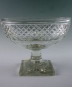 A Victorian table vase in the form of an eye glass with canted square star cut base, reeded column