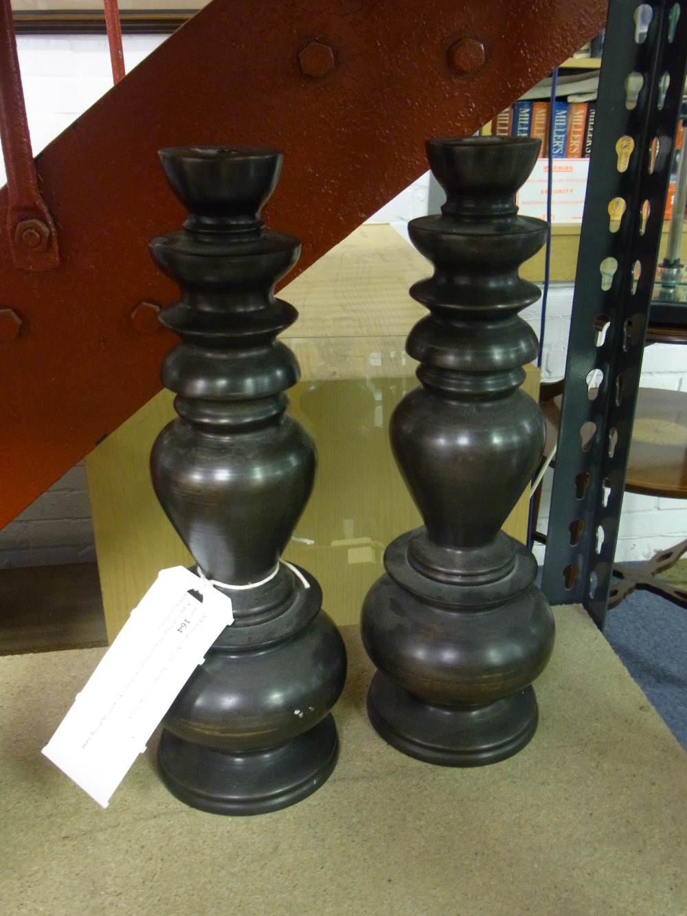 A pair of Thai heavy metal candlesticks with tapering vase and bun stems