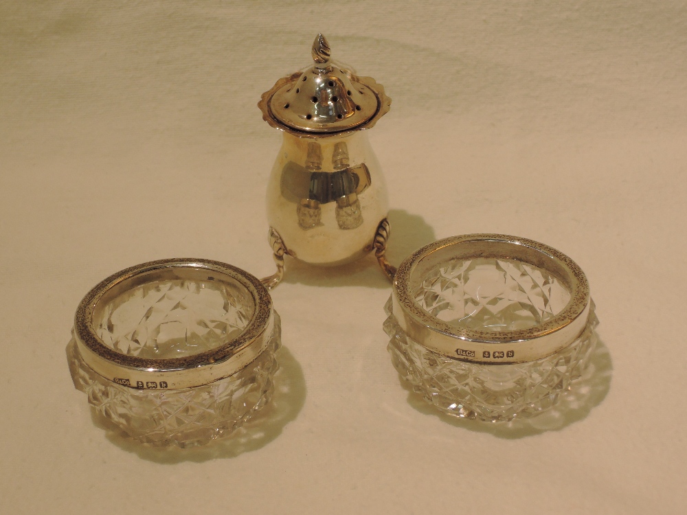 A silver pepper, Sheffield 1899 and a pair of silver mounted glass salts, Birmingham 1901