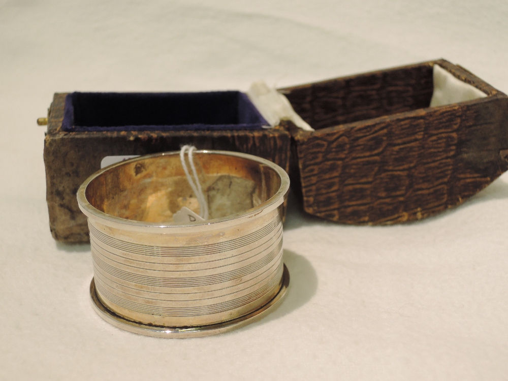 A cased silver napkin ring, having engine turned decoration, Chester 1924, J & R Griffin