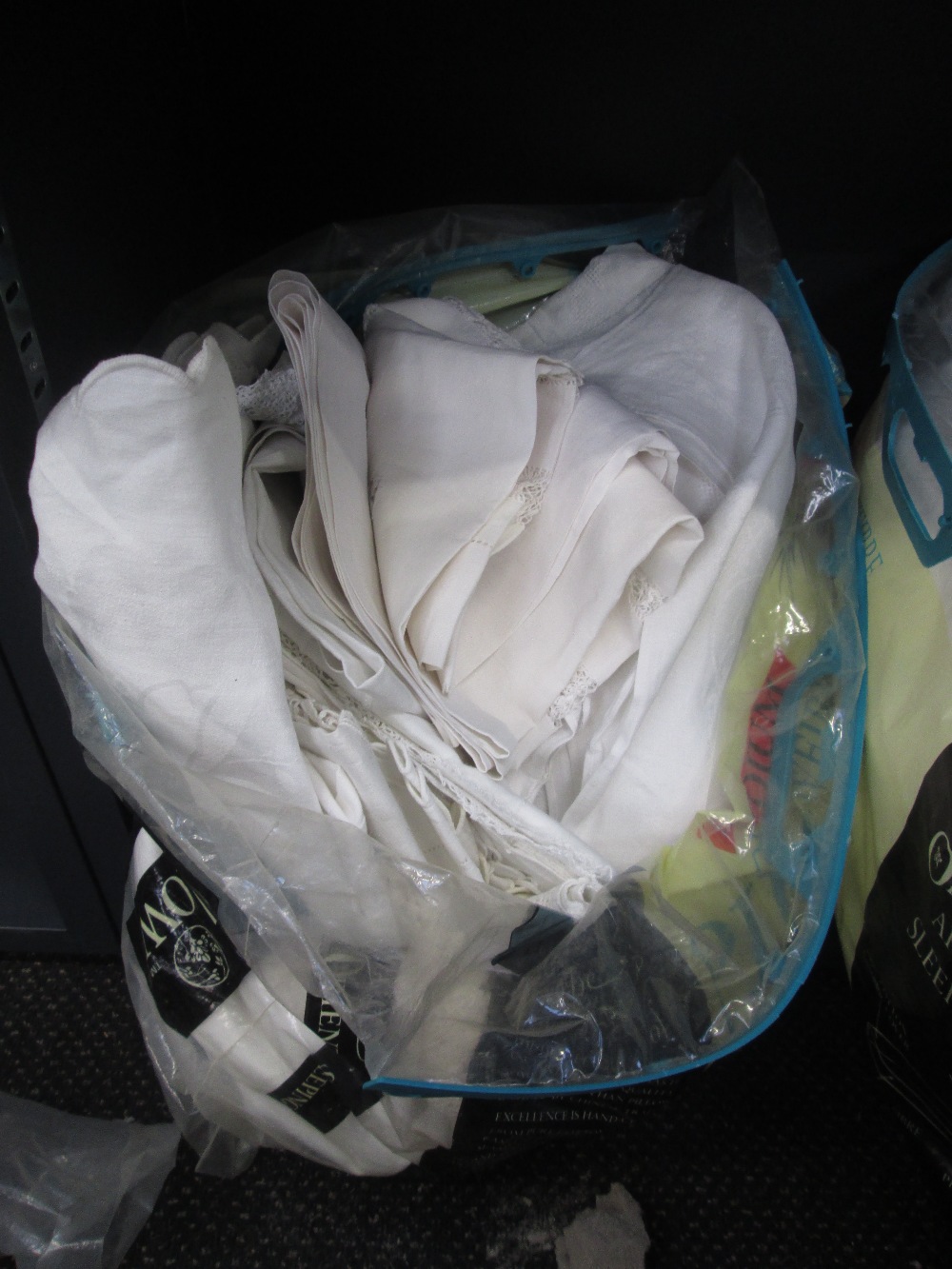 A bag of vintage linen and lace including table centres