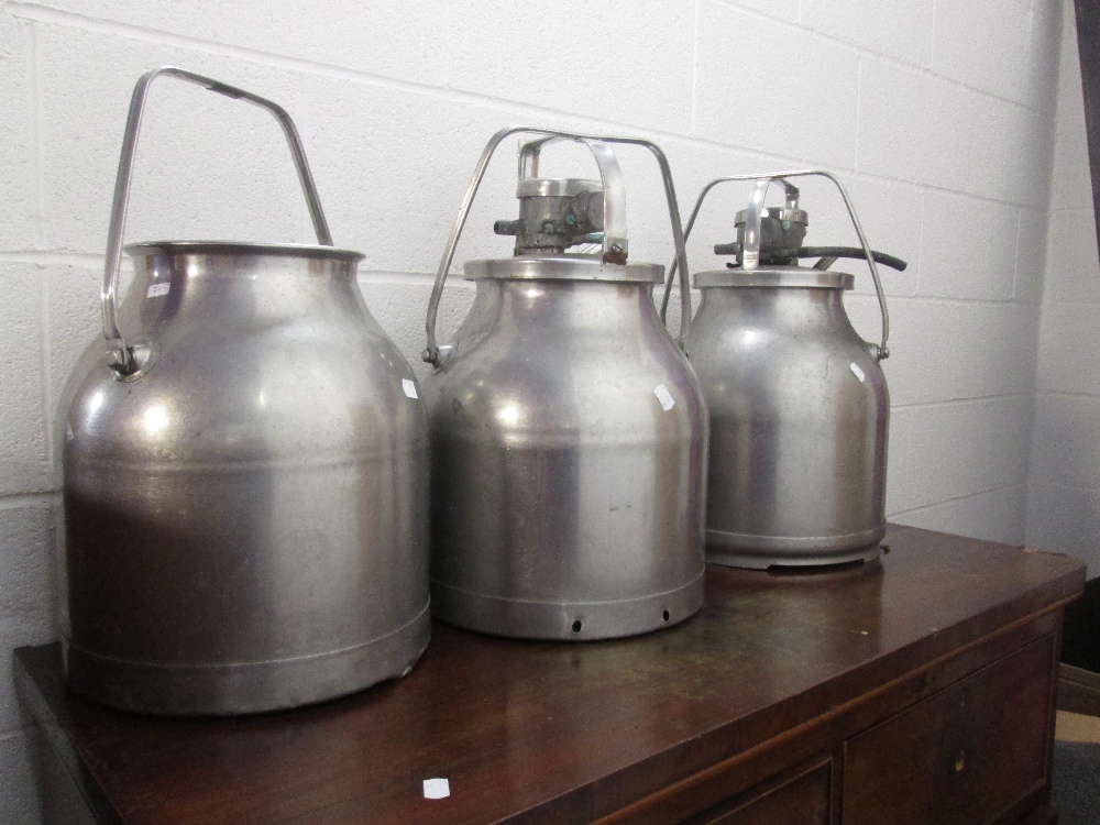 Three vintage stainless steel milk churns