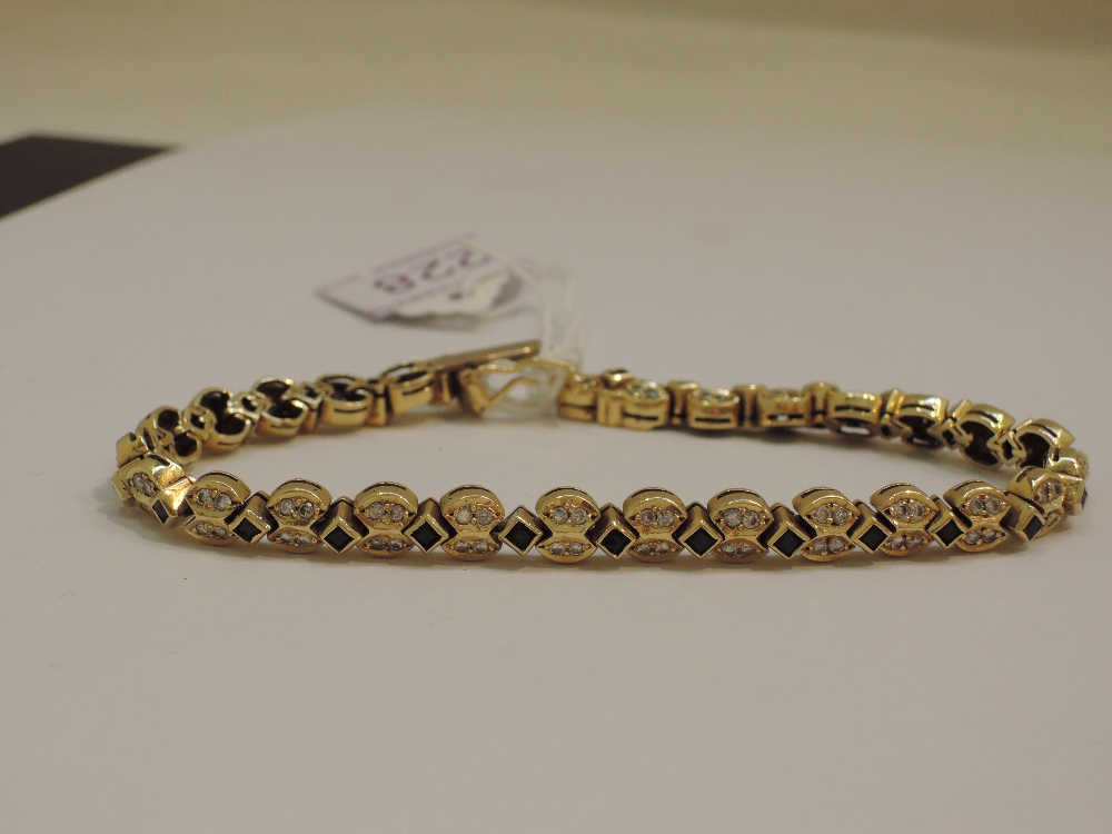An Egyptian articulated bracelet set with sapphires and diamond chips in 18ct gold, approx 28g