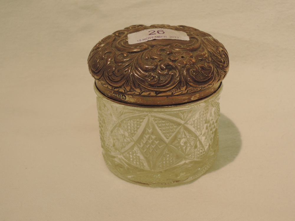 A silver mounted glass dressing table pot