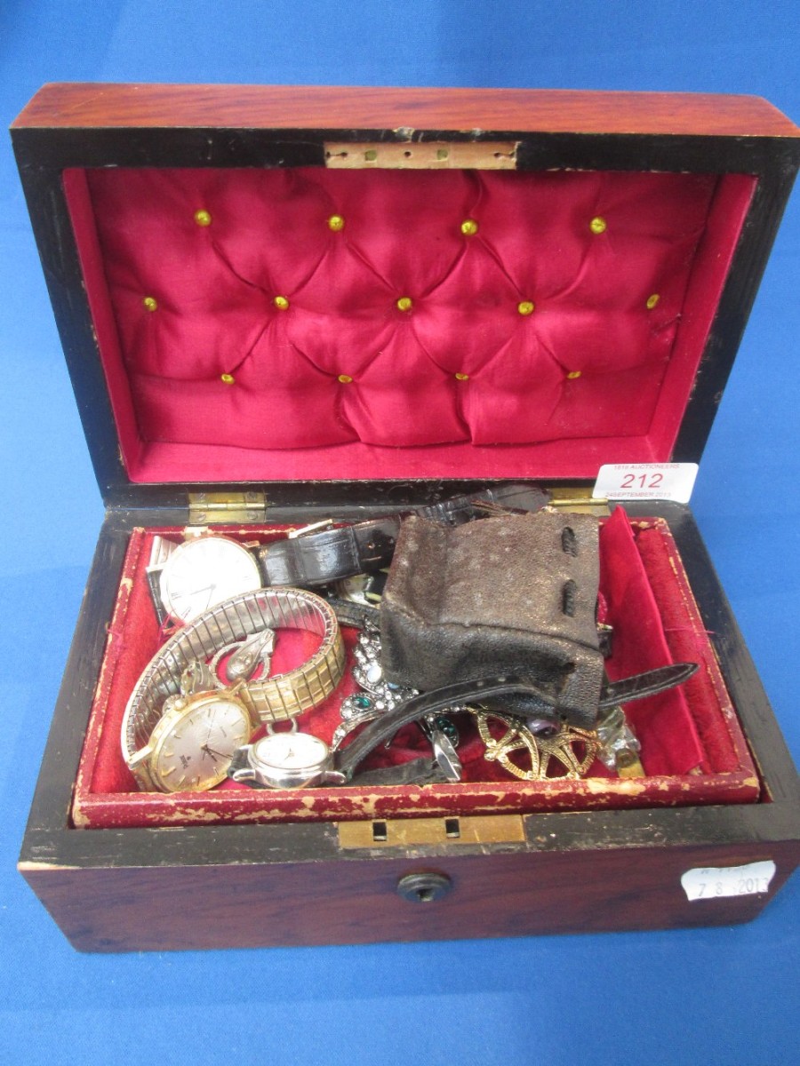 A small mahogany jewellery box containing a selection of costume jewellery including watches and