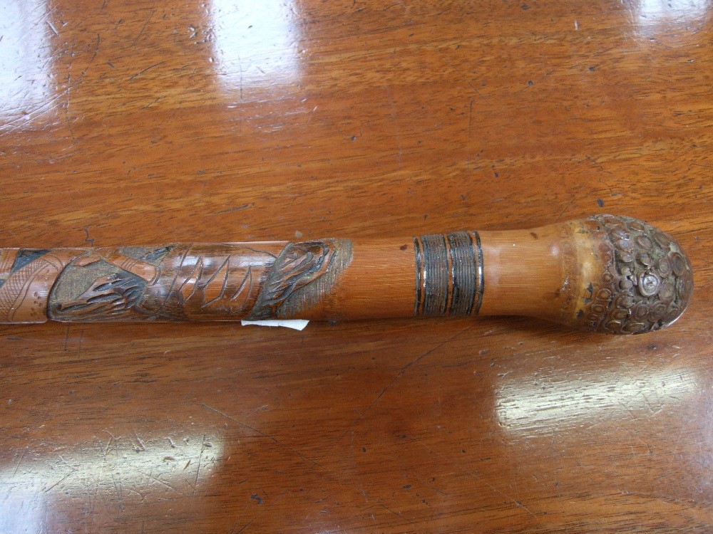 An Oriental carved walking stick of traditional design