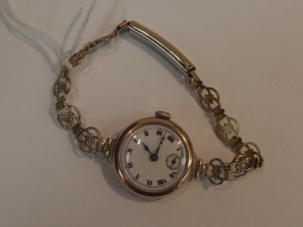 A ladies wrist watch having a Roman numeral dial and subsidiary seconds in a 9ct gold case on a