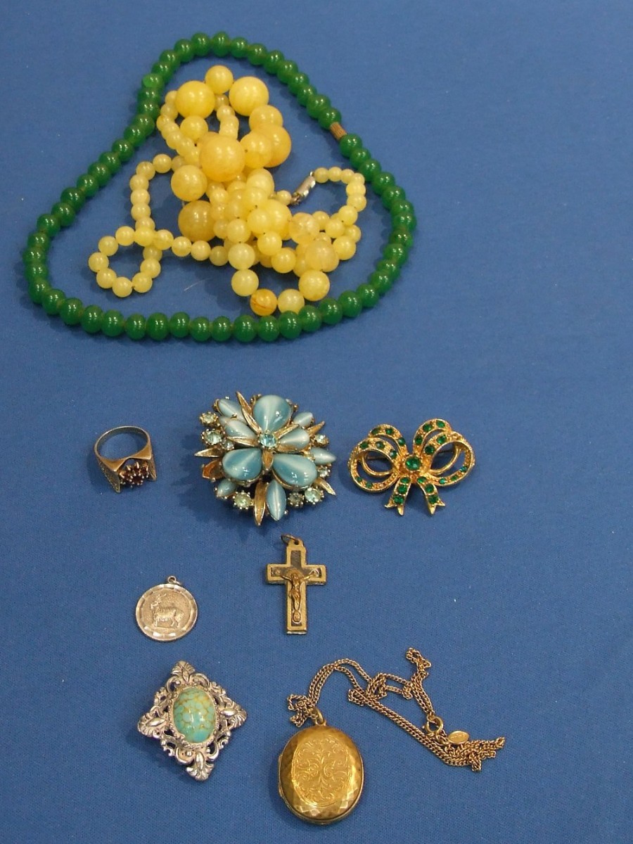 A small selection of costume jewellery including beads and brooches