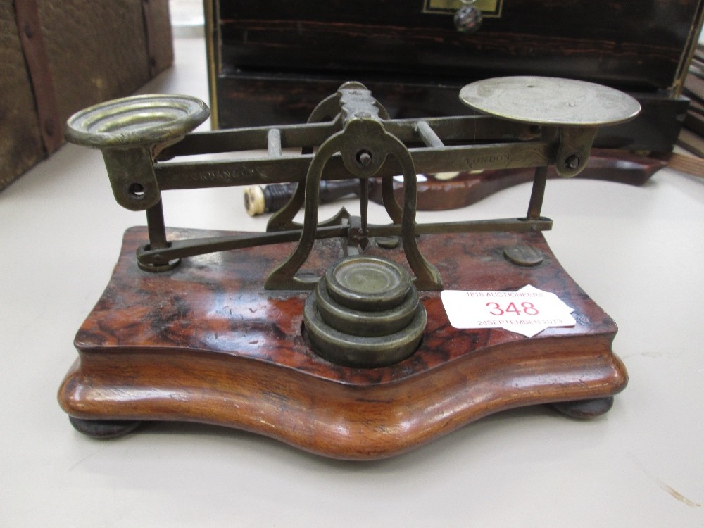 A set of 19th century ornate embossed brass postal scales on burr walnut base with weights
