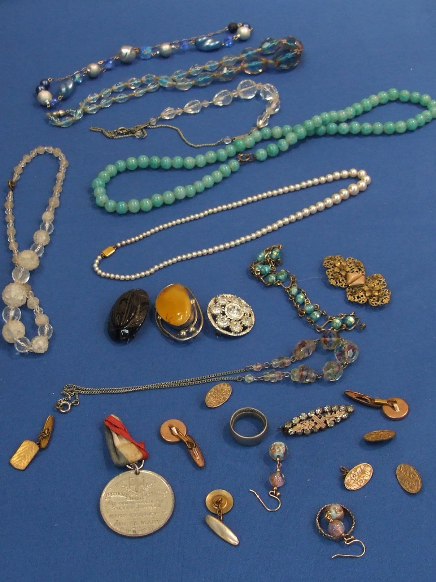 A selection of costume jewellery including Coronation medal, aquamarine coloured necklace etc