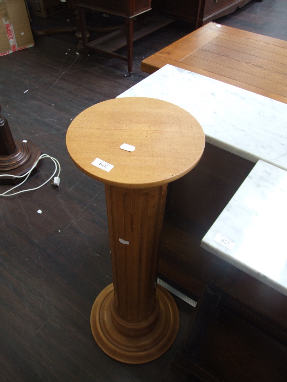 A modern rubberwood torchere pedestal