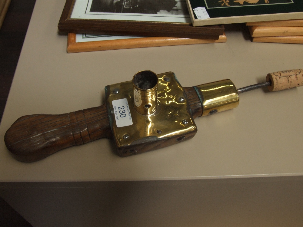 A 19th century rustic oak and brass candle holder, having spike attachment