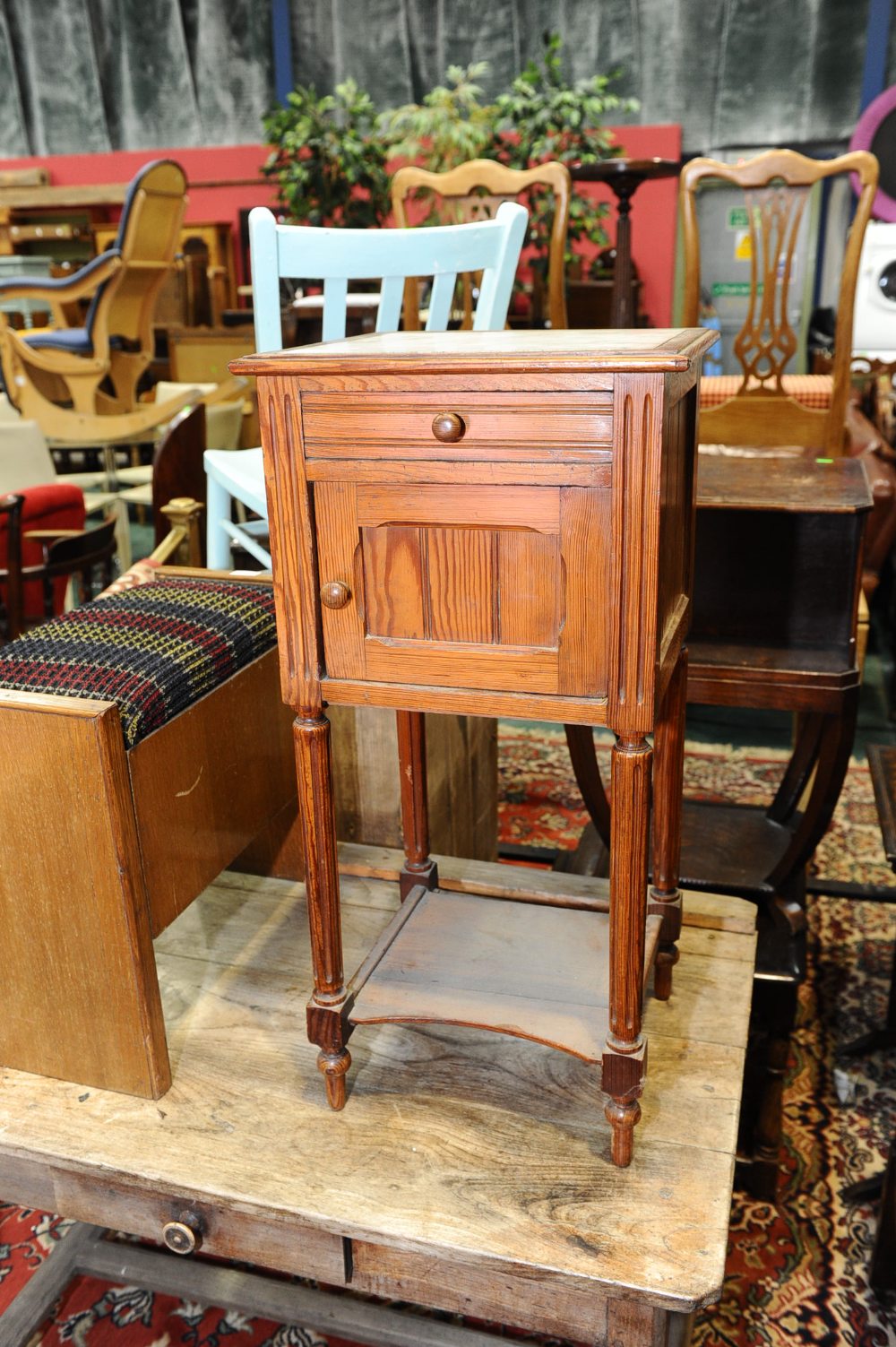 A 20th century pine pot cupboard with marble top raised on reeded supports