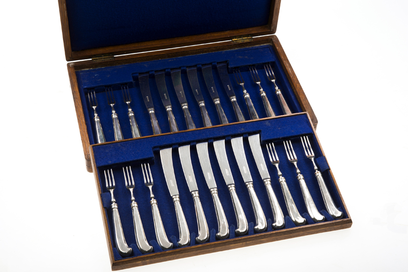 A LATE 19th CENTURY OAK-CASED CANTEEN OF TWELVE PISTOL-HANDLED SILVER-PLATED DESSERT KNIVES AND