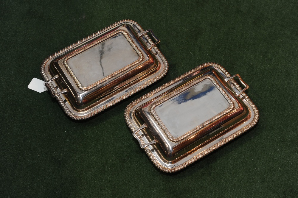 A pair of silver plated entree dishes with shell cast rims.