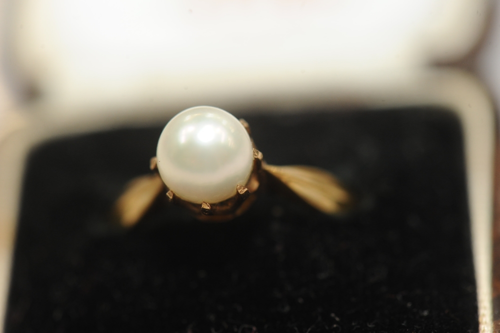 An 18ct gold cultured pearl ring, the single pearl claw-set on a tapering yellow gold band. Gross