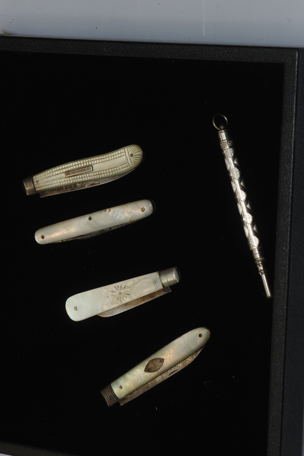 Three silver bladed mother of pearl folding fruit knives together with folding knife and a white