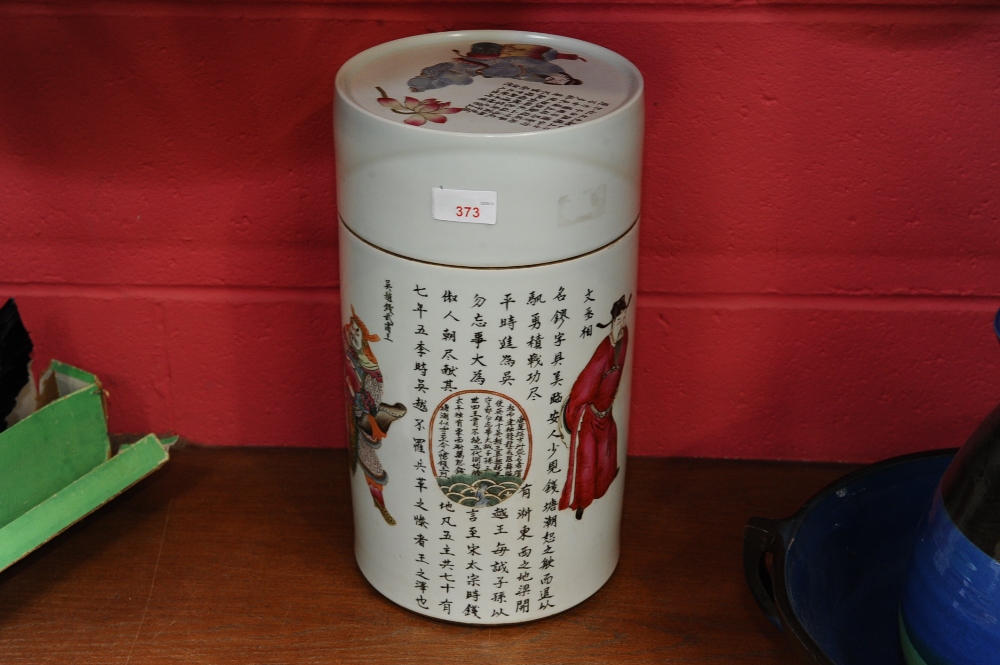 A large Chinese cylindrical covered jar, decorated with figures and calligraphy on a white ground,