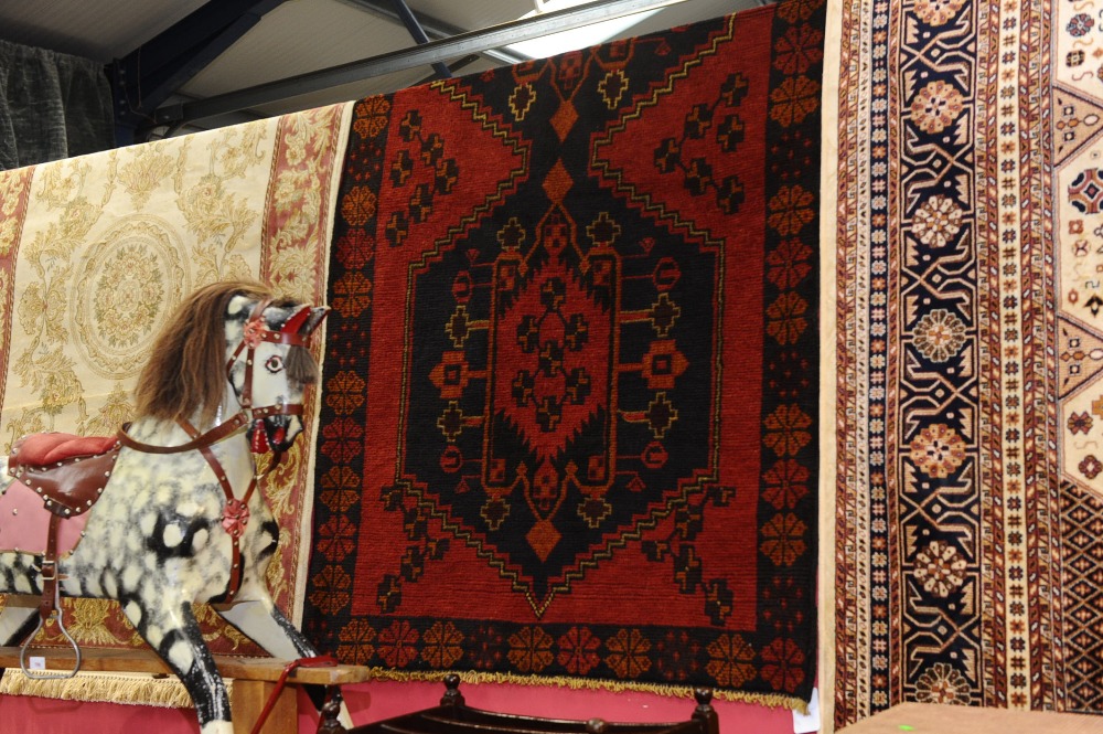 A  Persian belouch rug with a red ground. 1.82m x 1.1m