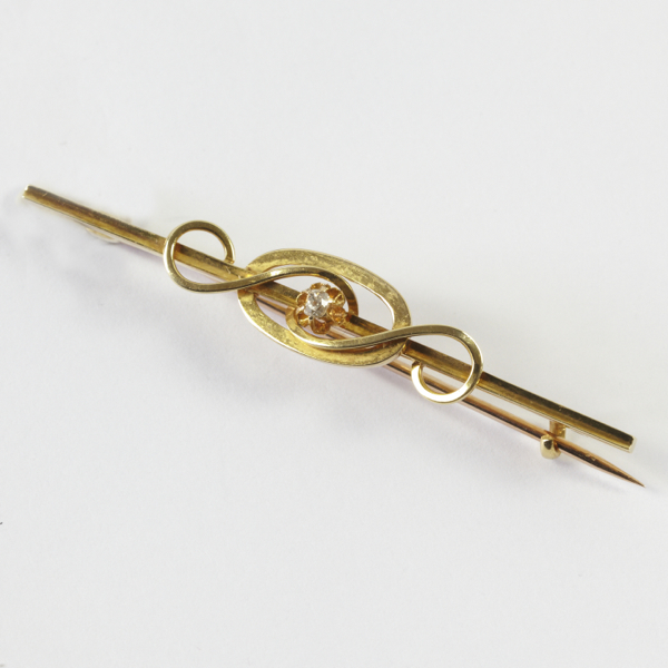 Antique bar brooch, approx. 55mm long, oval centre with entwined scrolls, old cut diamond to centre,