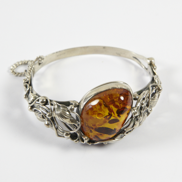 Ornate amber set bangle, approx. 36mm wide at front, large irregular oval shaped stone, approx. 32mm