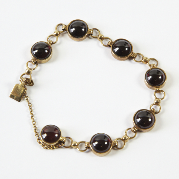 Ladies` garnet set bracelet, approx. 7", comprising seven round cabochon cut stones, each approx.