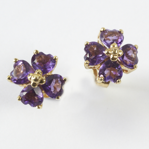 Pair of amethyst set stud earrings, comprising four heart shaped stones, with gold relief centre,