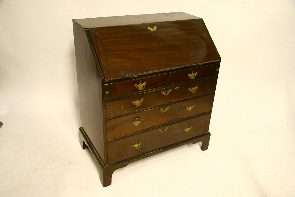 A mid-18th century mahogany bureau, the sloping fall front enclosing fitted interior, two short &