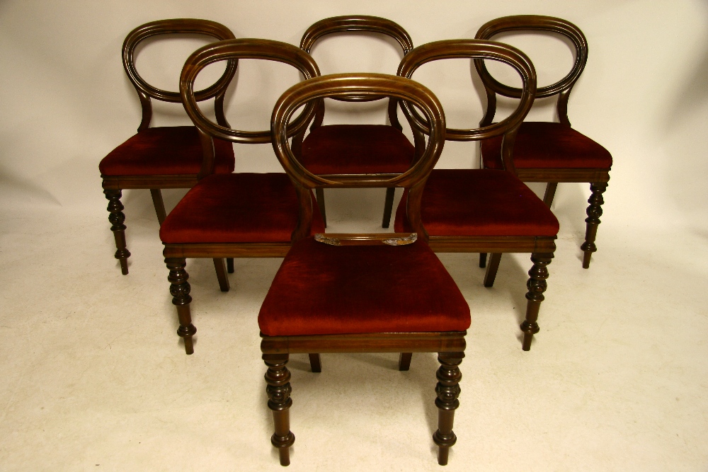 A set of six mid-Victorian mahogany “balloon-back” dining chairs with padded drop-in seat, & on