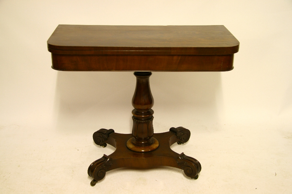 A William IV figured mahogany card table with rectangular fold-over top, on turned & carved centre