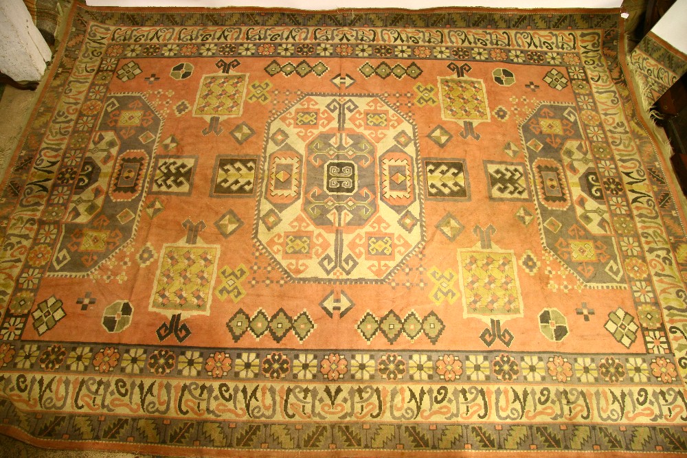 A machine-made carpet of Persian design, pink ground, with all-over geometric pattern in pastel