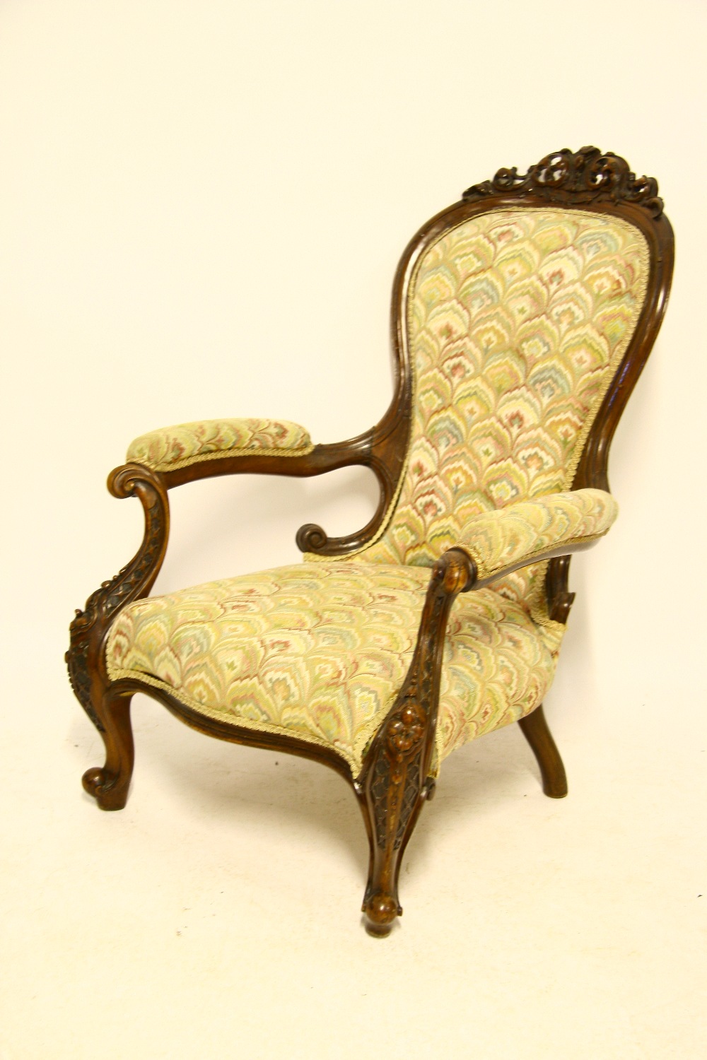 A Victorian carved & pierced walnut frame armchair with rounded back, padded open arms, sprung seat,