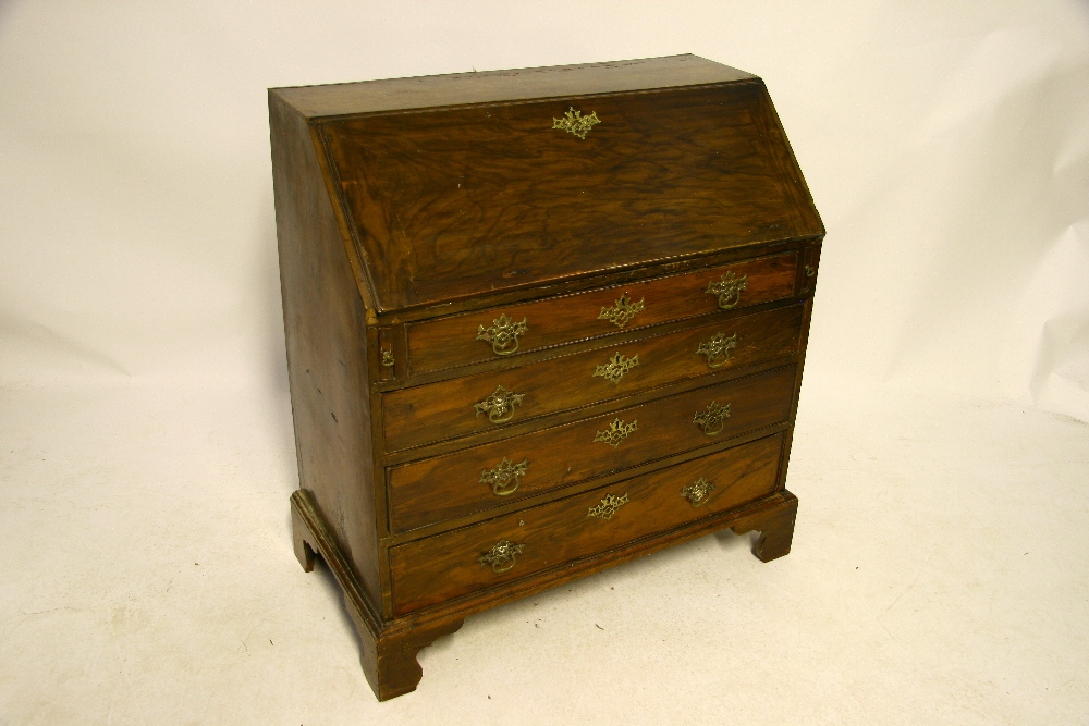 An 18th century walnut bureau, the sloping fall front enclosing fitted interior with blind-fret