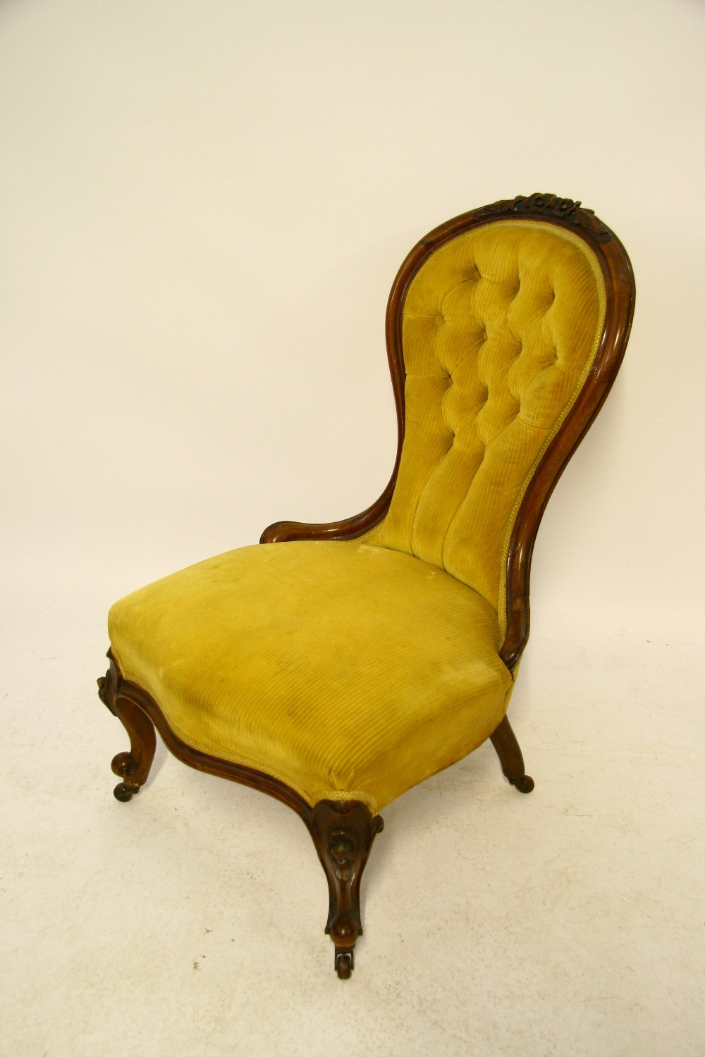 A mid-Victorian carved mahogany frame spoon-back easy chair on short carved cabriole legs.