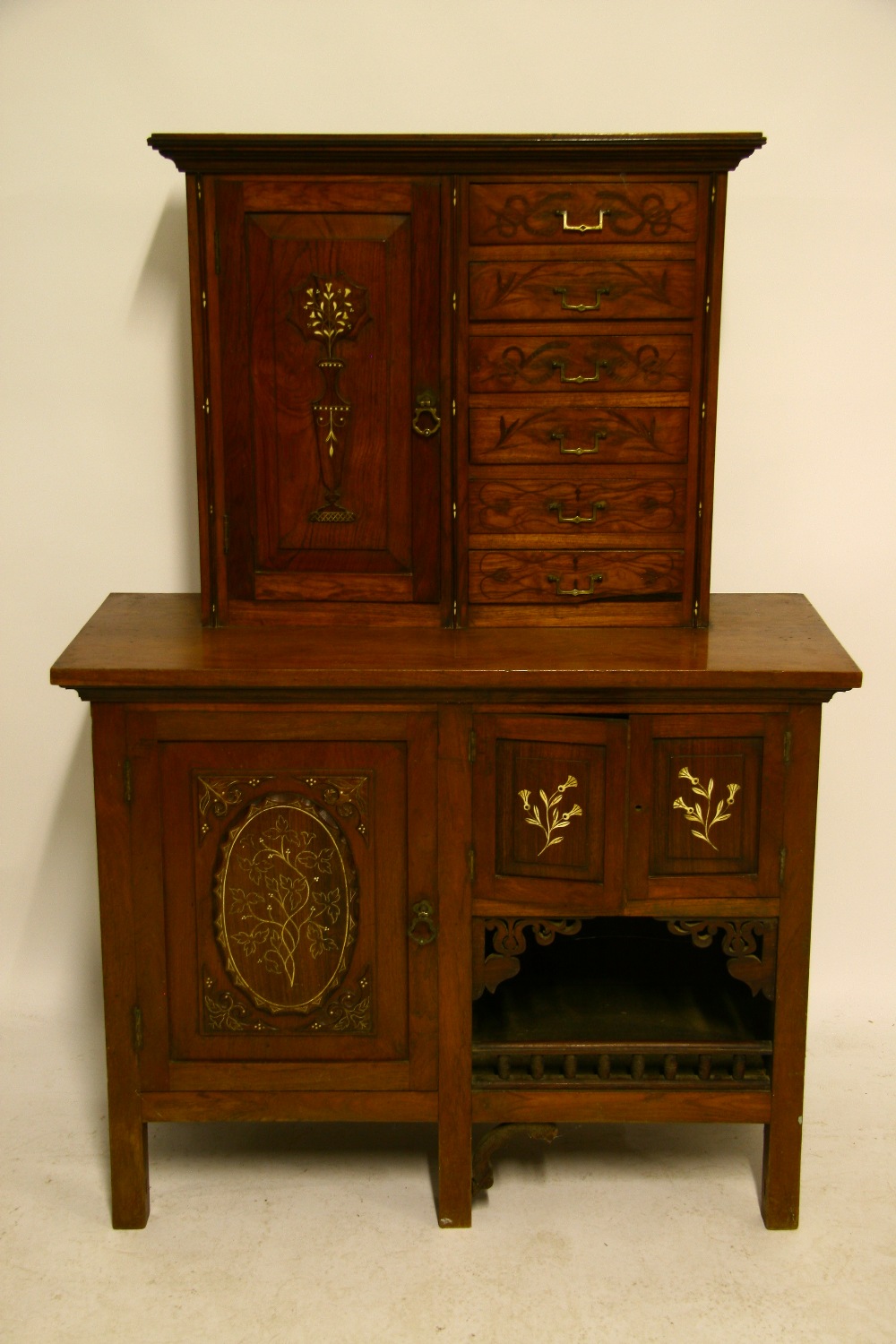 A 19th century continental walnut cabinet with bone-inlaid floral decoration, the upper part with