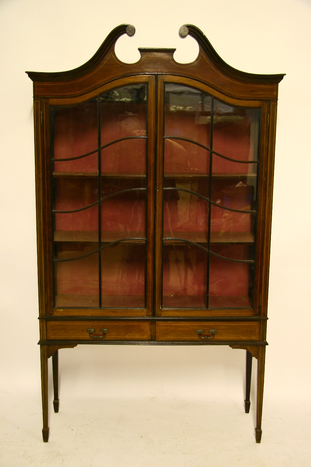 An Edwardian inlaid mahogany display cabinet with swan-neck cornice, enclosed pair of glazed