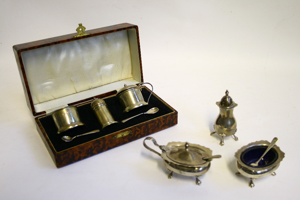 A three-piece condiment set of cylindrical form, Birmingham 1939, in fitted case; & another with