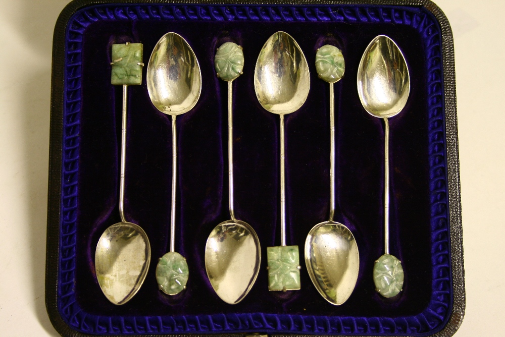 A set of six Chinese coffee spoons with carved jade terminals; in fitted case.