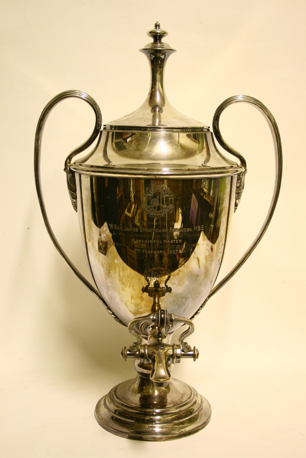 A vase-shaped tea urn with reeded loop side handles, engraved inscription, & on round pedestal foot;