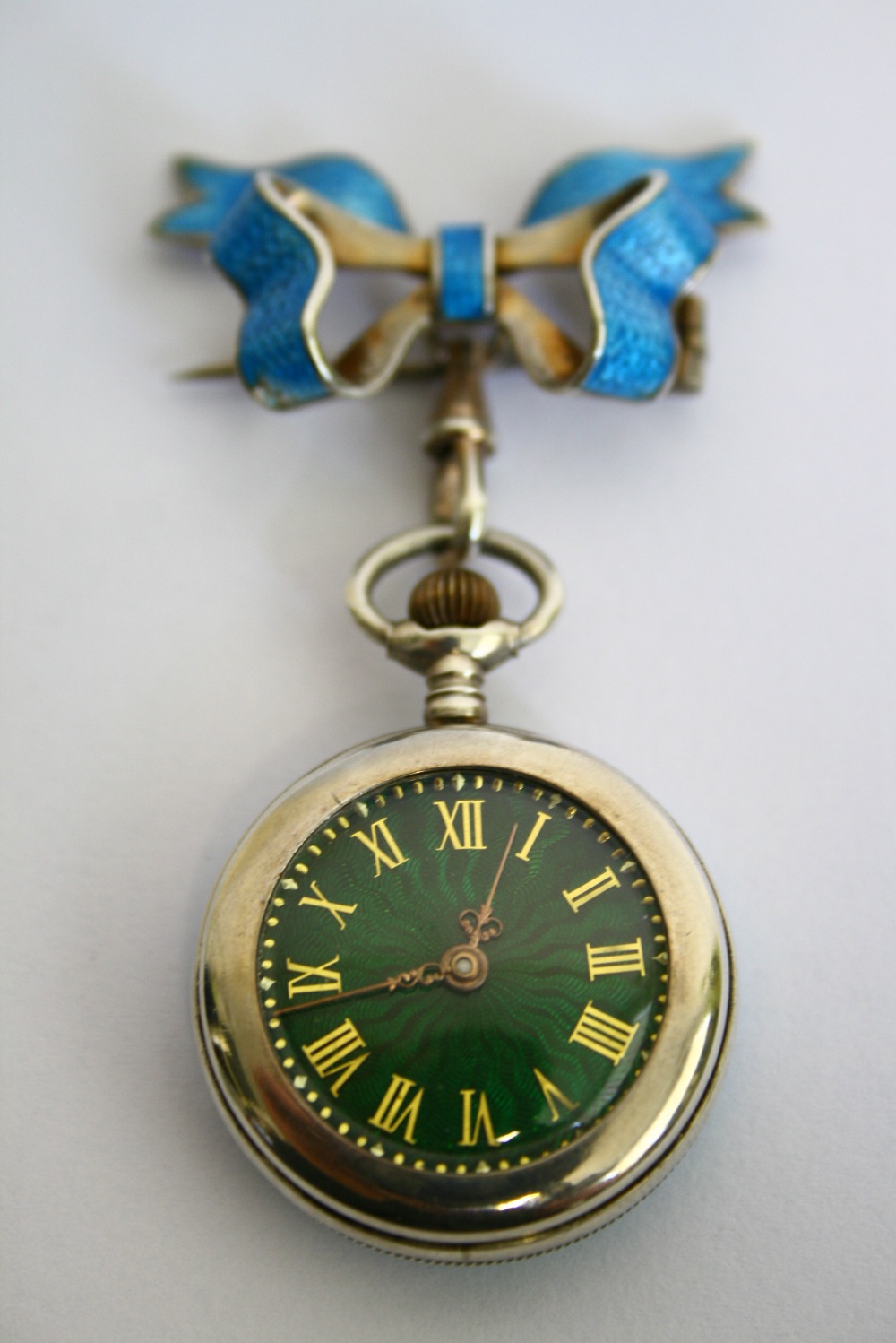 A SILVER & ENAMEL FOB WATCH, the green guilloche enamel dial with gilt roman numerals, the reverse