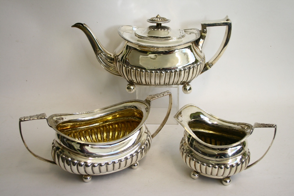 A REGENCY MATCHED THREE-PIECE TEA SERVICE of compressed oblong semi-fluted form, with reeded