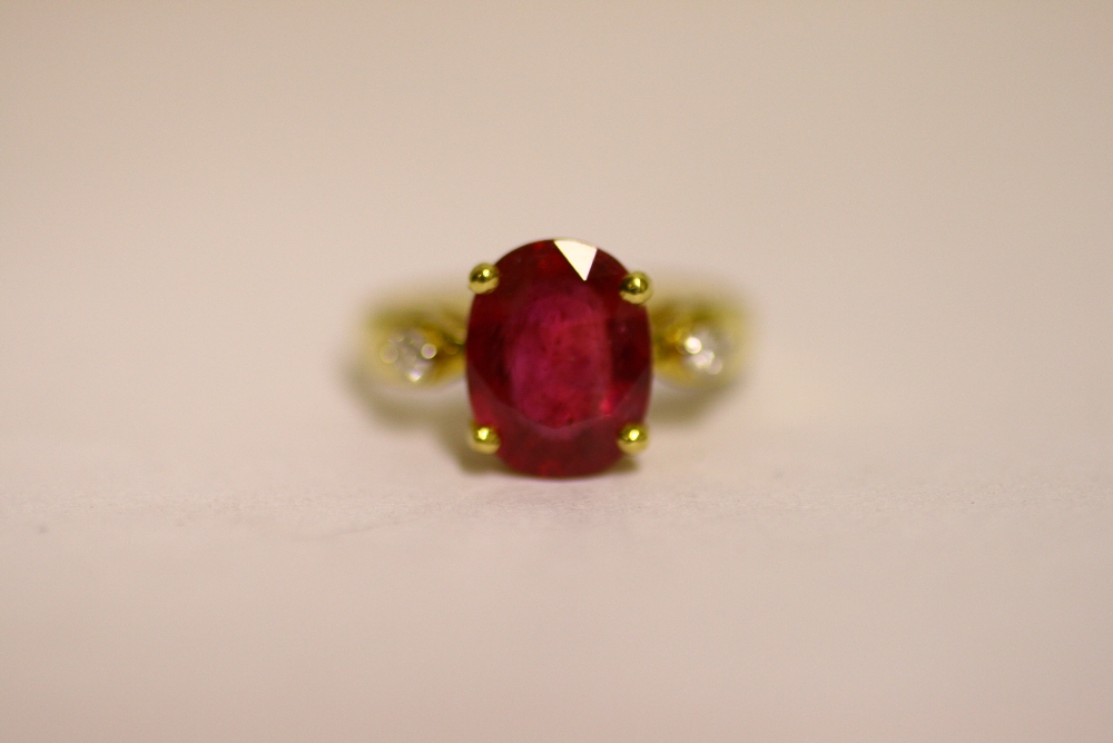 A RUBY & DIAMOND RING, the large cushion-shaped ruby measuring approx. 10.5mm x 8mm, a small diamond