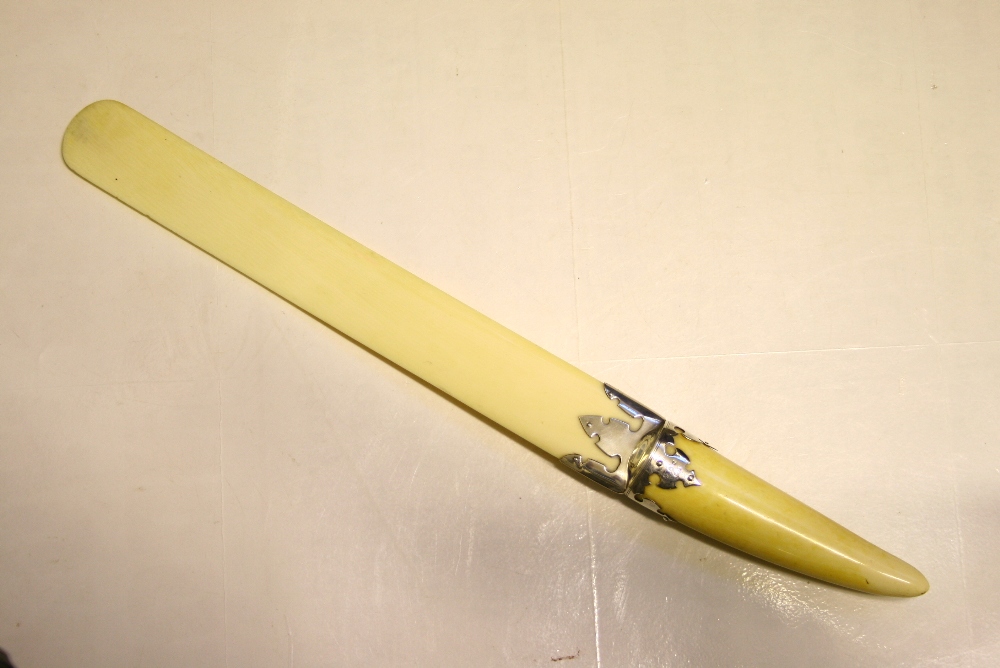 A LATE VICTORIAN SILVER-MOUNTED IVORY LARGE PAPER KNIFE, the 1¾" wide flat blade with rounded end,