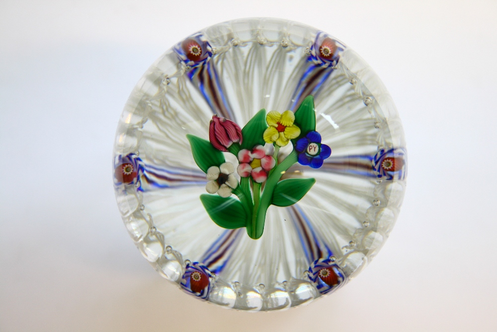 A Paul Ysart glass paperweight with a bouquet of flowers within a border of coloured spiral &