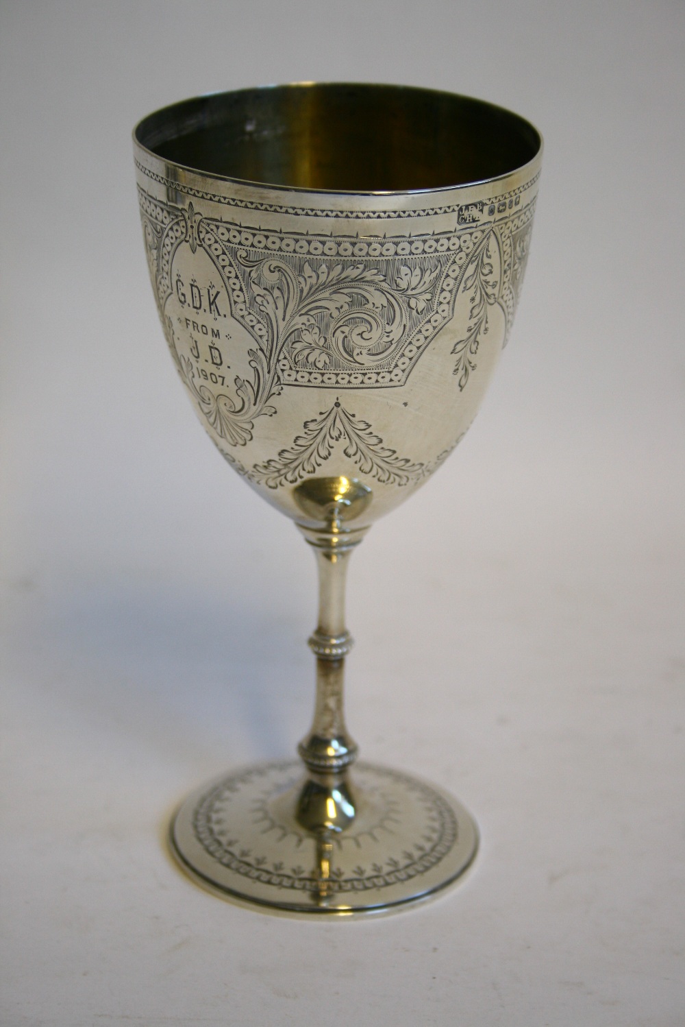 A Victorian goblet with foliate engraved ovoid bowl, inscription & date 1907, on slender stem &